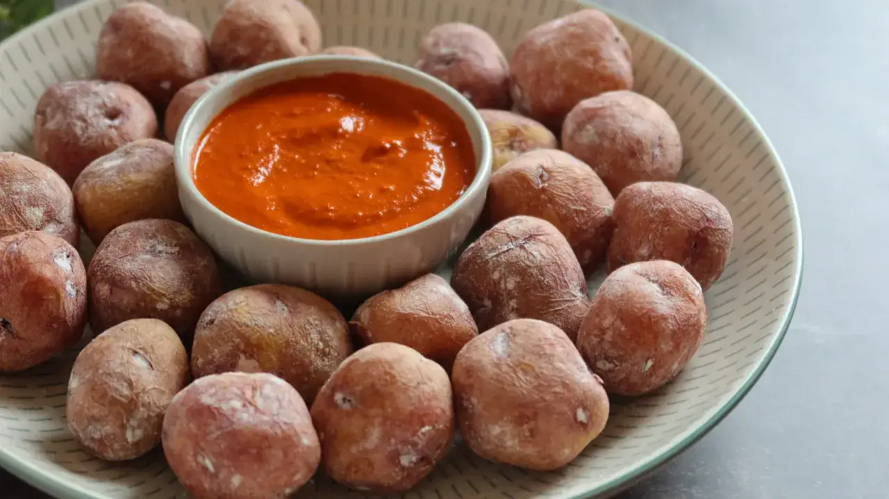 Papas arrugadas con sal marina y un cuenco de mojo rojo picante.