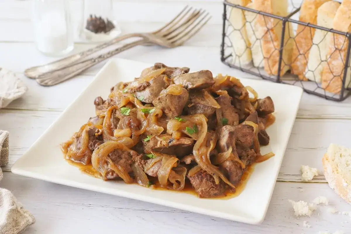 Sabrosos higaditos de pollo encebollados, un plato casero listo para disfrutar con pan.