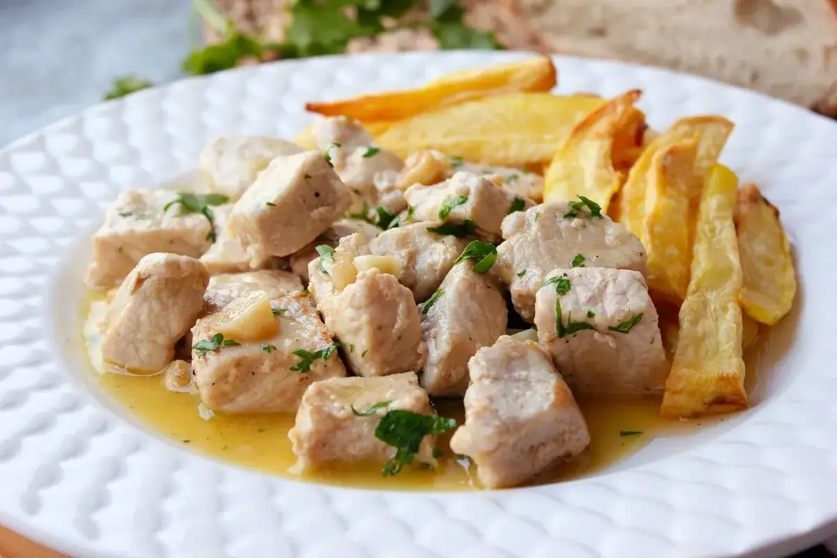 Sabroso solomillo al ajillo, tierno y jugoso, servido con patatas fritas crujientes.