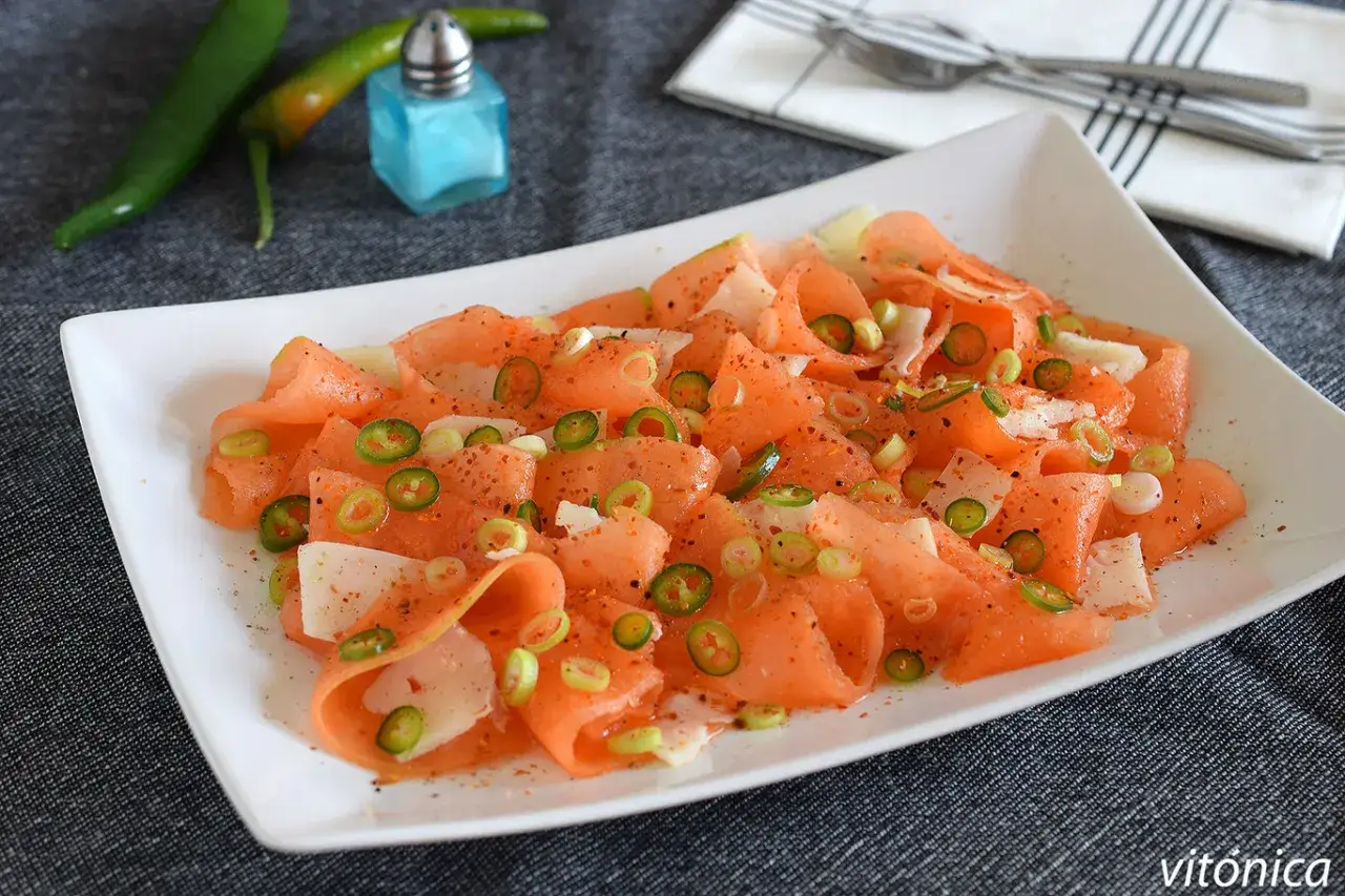 Deliciosa ensalada de melón con rodajas de chile jalapeño y cebolleta, un toque picante y refrescante.