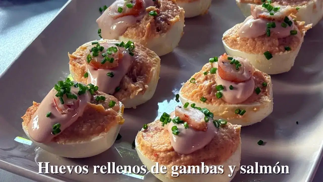 Huevos rellenos espectaculares de gambas y salmón, decorados con cebollino fresco y una cremosa salsa rosada.