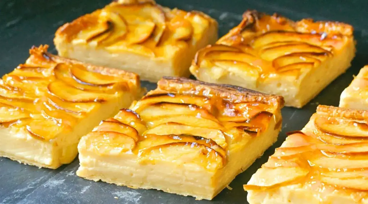 Porciones de tarta de manzana con crema pastelera, cubiertas con glaseado brillante y rodajas de manzana caramelizadas.