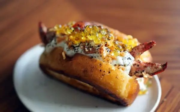Un delicioso lobster roll receta, con carne de cangrejo, caviar y salsa cremosa en un pan tostado.