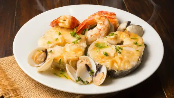 Merluza a la marinera con gambas y almejas, un plato delicioso y aromático.