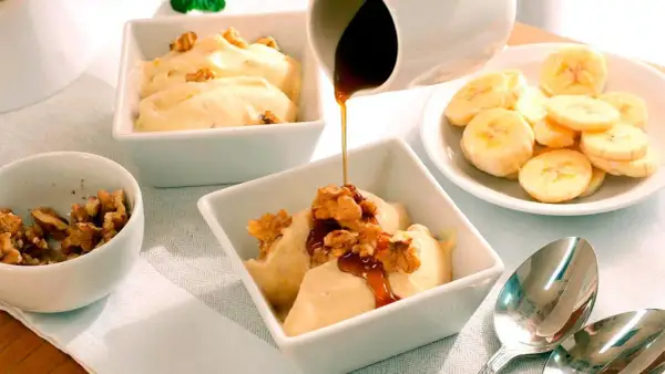 Disfruta de hacer helado casero con esta deliciosa receta de banana y nueces, cubierta con sirope.