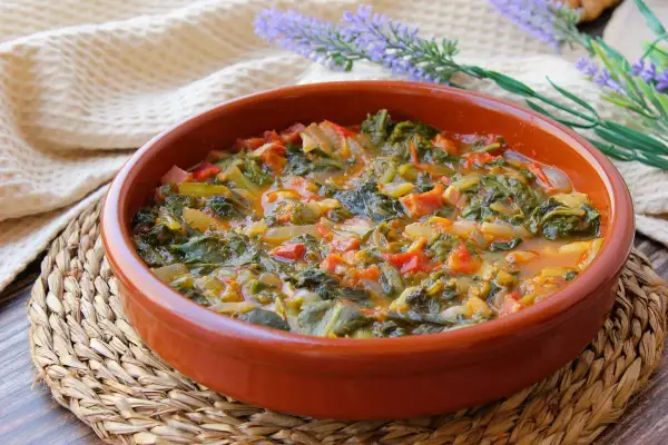 Un plato humeante de acelgas guisadas con tomate y cebolla, perfecto para tus recetas con acelgas.