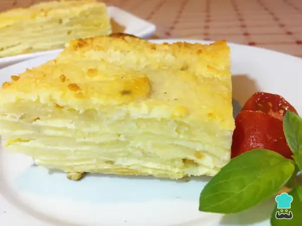 Delicioso pastel de papa en capas, un milhojas de patata gratinado, servido con tomates y albahaca.