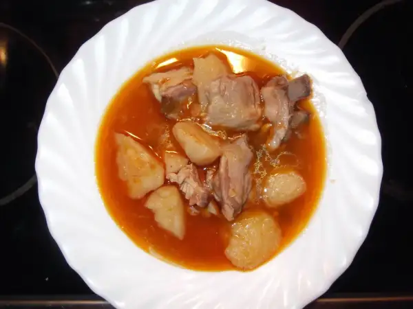 Plato de patatas con costillas en salsa roja. Un guiso casero que reconforta el alma.