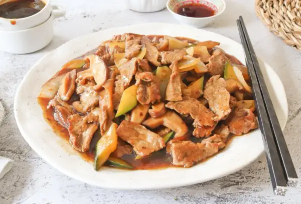 Ternera salteada con champiñones y calabacín en una rica salsa de ostras, lista para disfrutar con palillos.