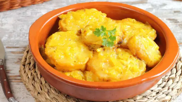 Patatas a la importancia, un plato reconfortante y delicioso, servido en cazuela de barro con perejil fresco.