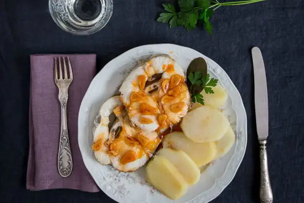 Merluza a la gallega servida con patatas cocidas y perejil. Un plato tradicional gallego.