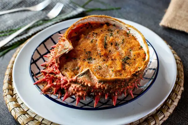 Txangurro a la donostiarra, un delicioso relleno de marisco gratinado dentro de su propio caparazón, listo para ser disfrutado.